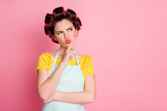 Portrait of pensive girl look copyspace think wear retro clothes hair curlers isolated on pastel color background