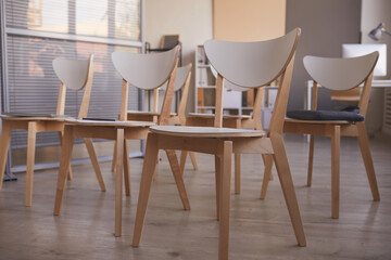 Close-up of wooden chairs standing at empty office for meeting