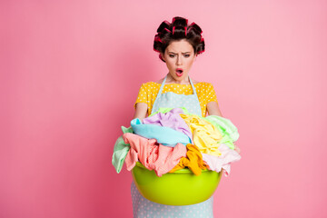 Portrait of her she attractive desperate puzzled overwhelmed housemaid carrying large pile dirty laundry isolated over pink pastel color background
