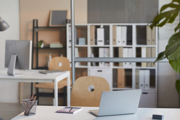 Image of desk with laptop for online work on it at modern office