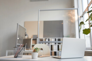 Image of desk with laptop for office worker at empty office