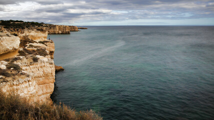 Coastal cliffs on the Arrifes shoreline on sunny day.Albufeira