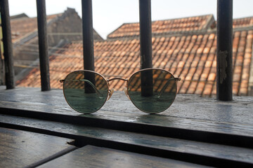 Sunglasses on wood plank table with rooftop of hoi an old town background at Hoi an Vietnam