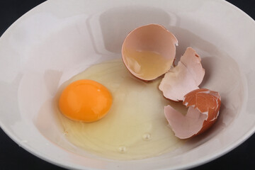 open egg with yolk ready to cook