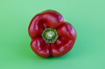 Red pepper against green background with copy space