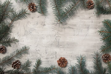 Grey Christmas background with green tree branches and cones with space for text. New Year. Christmas.
