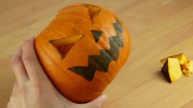 A man carves out a festive Halloween decor with his own hands. Scary pumpkin for Halloween in preparation. Drawing and carving pumpkin close-up.