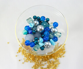 Blue beads in a glass standing on gold beads