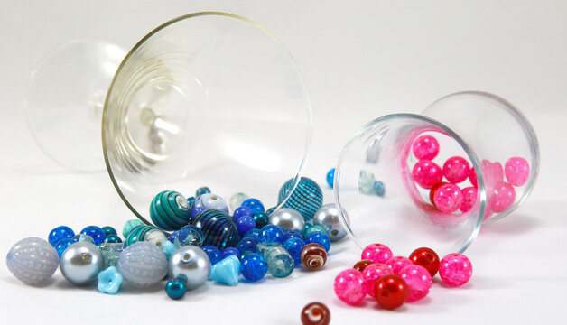 Blue and pink round beads on a white background with glasses