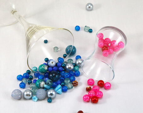 Blue and pink round beads on a white background with glasses