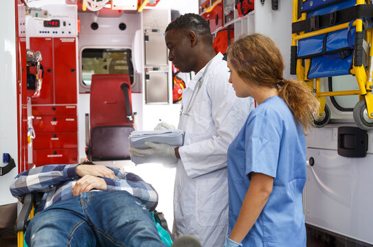 Emergency Doctor Asking Patient To Sign In Logbook At Ambulance Car