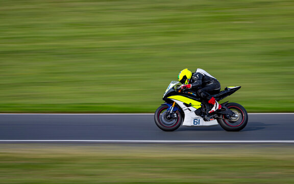 A Panning Shot Of A Racing Bike Cornering On A Track.