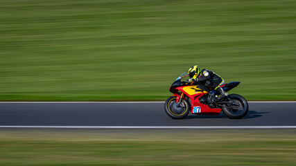 A panning shot of a racing bike cornering on a track.