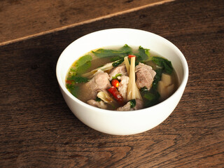 Bowl of Thai spicy pork rib soup on wooden table