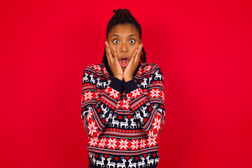 Scared terrified Young beautiful African American woman standing against red background shocked with prices at shop, People and human emotions concept