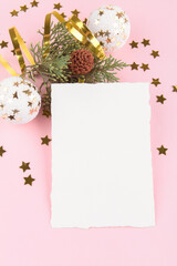 Christmas card mockup template with fir twigs and golden stars and festive decoration on a pink pastel background. Design element for CHristmas and New Year congratulation