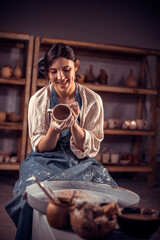 Obraz premium Creating a jar or vase. Master crock. Making clay jug. The sculptor in the workshop makes a jug out of earthenware closeup. Potter's wheel. Pottery concept.