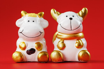 Naklejka premium A pair of cow and bull Figures on a red background, with free space.