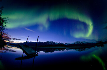 Fototapeta na wymiar Aurora over broken dock in Knik River, Alaska.