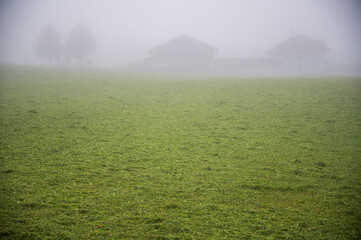 A farm on the horizon in the fog