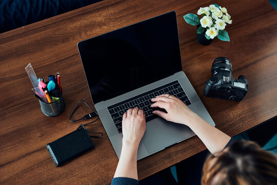 Female Photographer Working On Photos On Laptop And Camera. Woman Editing Retouching Browsing Photos Working As A Freelancer Sitting At Desk