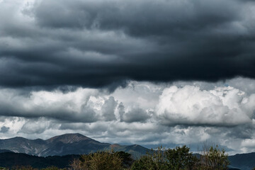 Gloomy coudy sky and dark mountains. Stormy weather and rainy clouds.