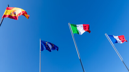 Flags of Spain, flag of European Union, flag of Italy and flag of France against the blue sky