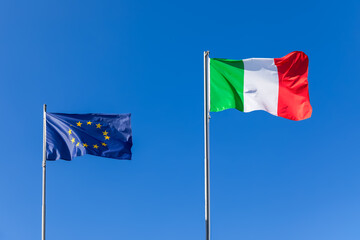 Flag of European Unione and flag of Italy against the blue sky