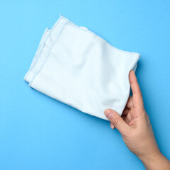 female hand holding folded blue napkin