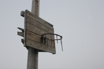 Old ruined ghetto style basketball hoop. Basketball ring with chains against grey sky with copy space.