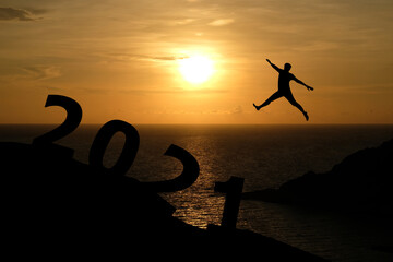 Concept Happy new year 2021 Silhouette image of happy man jump up to 2021 on beautiful sunrise background.