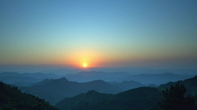 Time-lapse of golden sunset scene above mountaintop, static shot, copy space