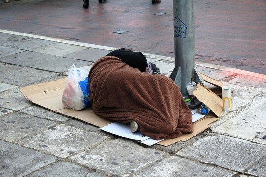 Unidentified homeless person sleeping on street pavement at Syntagma square in Athens, Greece, November 6 2020.