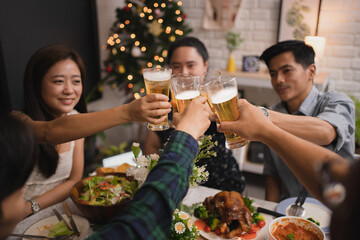 Group of Asian people are very happy and enjoy at the party. They clink a glass of beer.