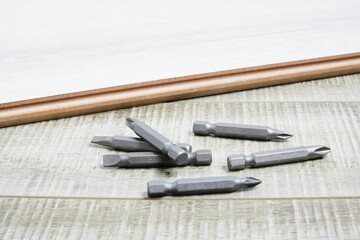 Set of metal bits for screwdriver on wooden background copy space