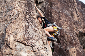 cute teen kid climbing on rock with insurance, lifestyle sport people concept