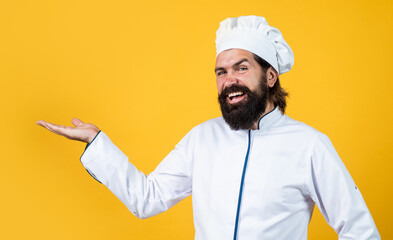 presenting product. handsome man with beard and moustache cooking food. professional restaurant cook baking. skilled baker use kitchen utensils for cooking. male chef in hat prepare healthy meal