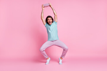 Full length photo of cheerful funny young guy dressed casual clothes listening music modern gadget...
