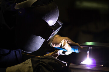 Metal workers use manual labor, Skilled welder, Factory workers making OT. Welder is welding the steel in the factory.