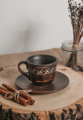 Handmade ceramic craft ware. Rustic napkin and kitchen tools with lavender and candle. Ceramic cup with cinnamon on a wooden stand. Handmade ceramic dishes