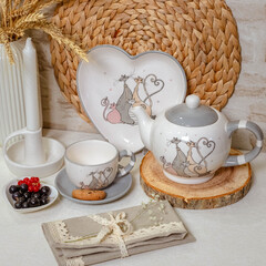 A teapot with a cup, a candle and cookie. Kitchen set