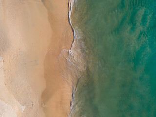 Aerial view of drone. Top view beach sea sand and surf. In summer day. Seawater on sandy beach. Nature background and travel concept.