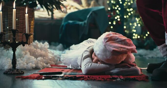 Sleeping girl receiving gift from Santa Claus