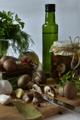 Mushrooms, spices and a jar of pickled champignons on the table.