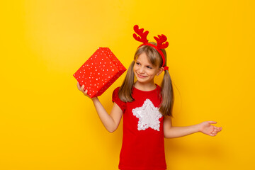 Kid wearing antlers holding Christmas present