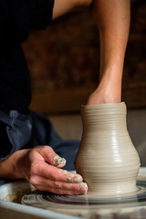 Female hands working with clay on a potter's wheel