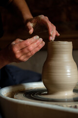 Fototapeta na wymiar Female hands working with clay on a potter's wheel