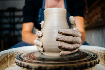 Fototapeta na wymiar Female hands working with clay on a potter's wheel