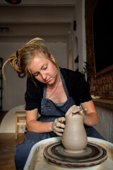 Woman making ceramic pottery on wheel, hands closeup. Concept for woman in freelance, business, hobby