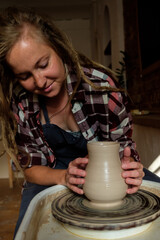 Woman making ceramic pottery on wheel, hands closeup. Concept for woman in freelance, business, hobby
